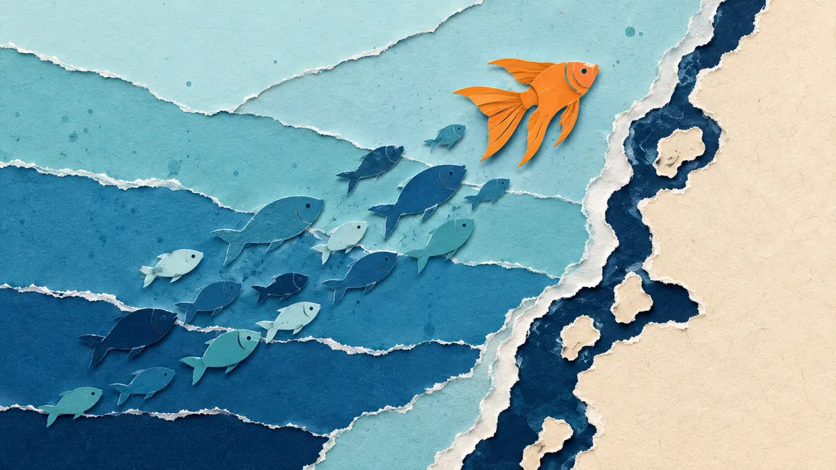 Illustrazione papercut di un banco di pesci di carta blu che risale lungo una costa stilizzata, guidato da un pesce arancione di acque calde con pinne a ventaglio